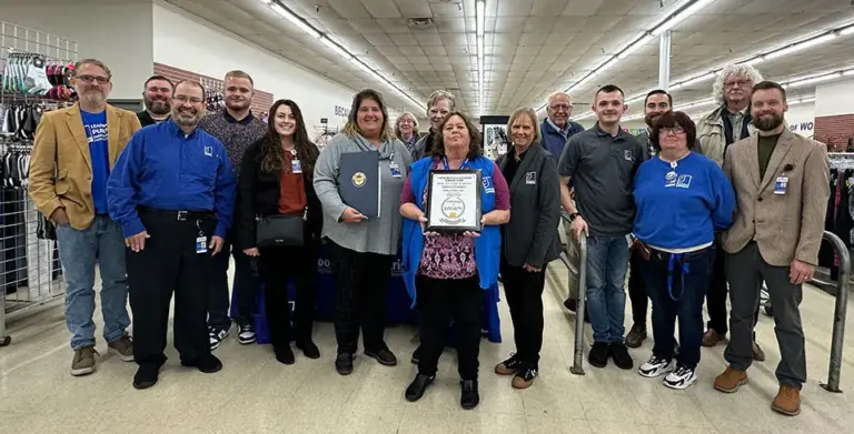 Marion Goodwill management team poses with 20th anniversary plaque.